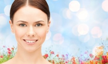 health, people and beauty concept - beautiful young woman face over poppy field background