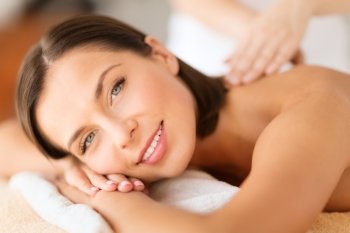 health, beauty, resort and relaxation concept - beautiful woman with closed eyes in spa salon getting massage