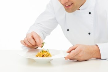 cooking, profession, haute cuisine, food and people concept - close up of happy male chef cook decorating dish