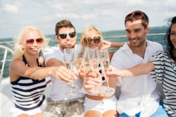 vacation, travel, sea, holidays and people concept - close up of happy friends clinking glasses of champagne and sailing on yacht
