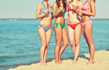 summer vacation, holidays, party, travel and people concept - close up of young women with ice cream on beach