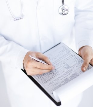 close up of male doctor holding prescription paper in hand. male doctor holding prescription paper in hand