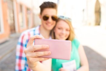 travel, summer vacation, technology and love concept - close up of happy couple taking selfie with smartphone in city