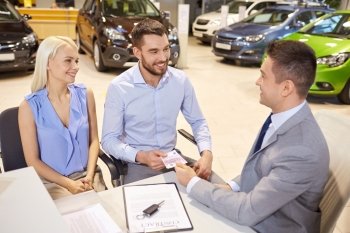 auto business, sale and people concept - happy couple with dealer buying car in auto show or salon