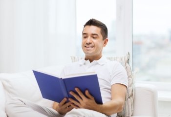 leisure, education, literature and people concept - happy man reading book at home