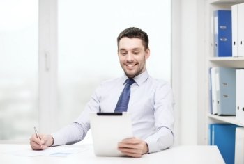 office, business, technology, finances and internet concept - smiling businessman with tablet pc computer and documents at office