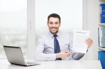 business, office and technology concept - smiling businessman with laptop computer and contract at office