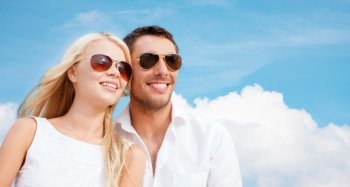 summer holidays, people and dating concept - happy couple in shades over blue sky and white cloud background