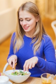 people, leisure, eating and food concept - happy young woman having dinner at restaurant, cafe or home