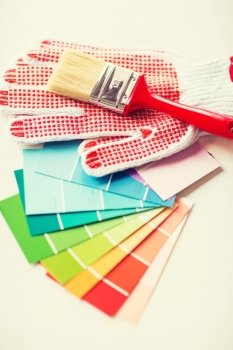 interior design and home renovation concept - paintbrush, gloves and pantone samplers