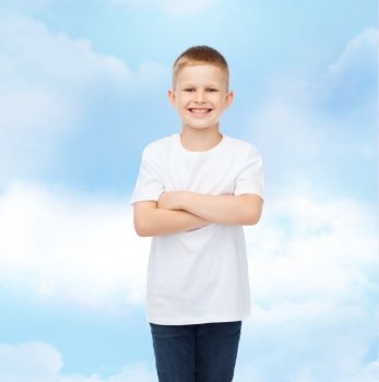 advertising, dream, people and childhood concept - smiling little boy in white blank t-shirt over cloudy sky background