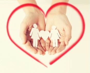 love, family and happiness concept - womans hands showing two paper women with heart shape