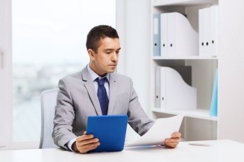 business, people, paperwork and technology concept - businessman with tablet pc and papers in office