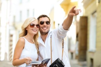 summer holidays, dating, city break and tourism concept - couple with camera and travellers guide