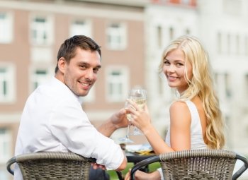 summer holidays and dating concept - smiling couple drinking wine in cafe in the city