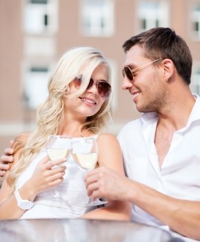 summer holidays and dating concept - couple drinking wine in cafe in the city