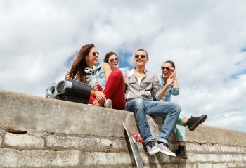 summer holidays and teenage concept - group of smiling teenagers with boob box and skatboard hanging out outside