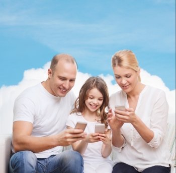 family, technology and people concept - smiling mother, father and little girl with smartphones over blue sky and white cloud background