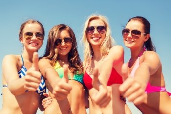summer vacation, holidays, travel and people concept - group of smiling young women showing thumbs up over blue sky background