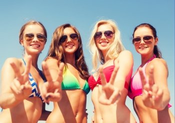 summer vacation, holidays, gesture, travel and people concept - group of smiling young women showing peace or victory sign over blue sky