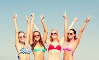 summer vacation, holidays, gesture, travel and people concept - group of smiling young women showing peace or victory sign over blue sky background