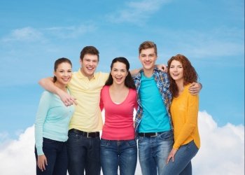 friendship, dream, future and people concept - group of smiling teenagers over blue sky with white cloud background