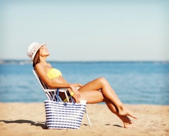 summer holidays and vacation - girl in bikini sunbathing on the beach chair. girl sunbathing on the beach chair