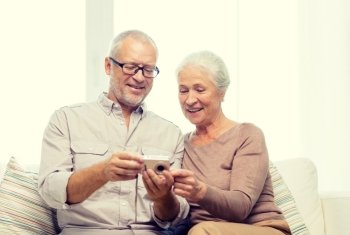 family, technology, age and people concept - happy senior couple with camera at home