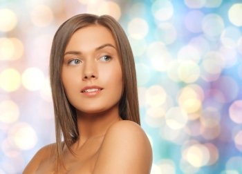 people, beauty, body and skin care concept - beautiful woman with bare shoulders over blue holidays lights background