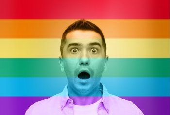 homosexual, homophobia, intolerance, emotions and people concept - shocked gay man shouting over rainbow flag background