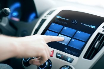 transport, modern technology and people concept - male hand pushing button on car control panel screen