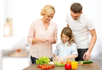 vegetarian food, culinary, happiness and people concept - happy family cooking vegetable salad for dinner over kitchen background