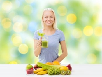 healthy eating, vegetarian food, diet, detox and people concept - smiling woman drinking green vegetable juice or shake from glass over summer green holidays lights background