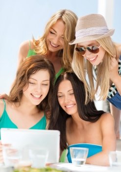 summer holidays, vacation, internet and technology concept - smiling girls looking at tablet pc in cafe