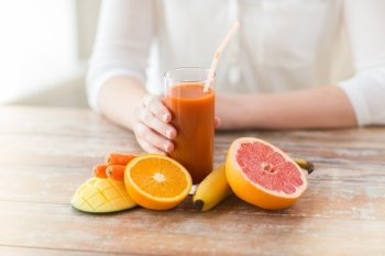 healthy eating, food, dieting and people concept - close up of woman hands with fruits and fresh juice sitting at table