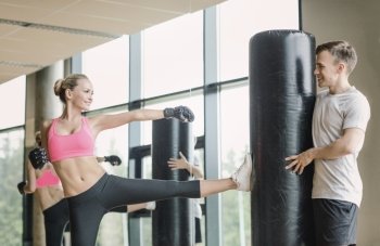 sport, fitness, lifestyle and people concept - smiling woman with personal trainer boxing in gym