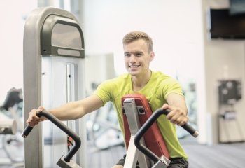 sport, fitness, lifestyle and people concept - smiling man exercising in gym