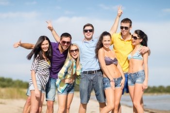 summer holidays, vacation, tourism, travel and people concept - group of happy friends having fun and showing victory gesture on beach
