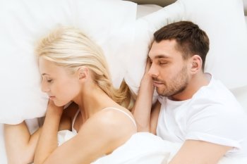 people, rest, relationships and happiness concept - happy couple of man and woman sleeping in bed