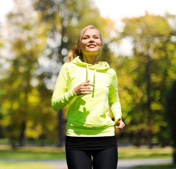 fitness and lifestyle concept - female runner jogging outdoors. woman jogging outdoors