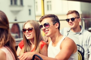 friendship, travel, vacation, summer and people concept - smiling couple traveling by tour bus