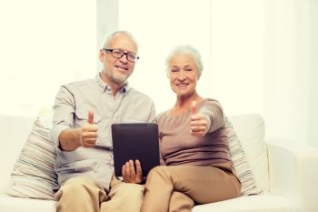 family, technology, age, gesture and people concept - happy senior couple with tablet pc computer showing thumbs up at home