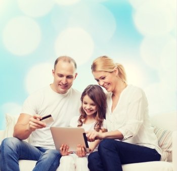 family, holidays, shopping, technology and people - smiling family with tablet pc computer and credit card over blue lights background