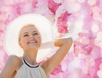 fashion, happiness and lifestyle concept - beautiful woman in hat enjoying summer outdoors