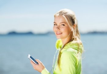 fitness and lifestyle concept - woman doing sports and listening to music outdoors. woman listening to music outdoors