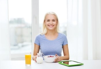 healthy eating, dieting and people concept - smiling young woman with tablet pc computer eating breakfast at home