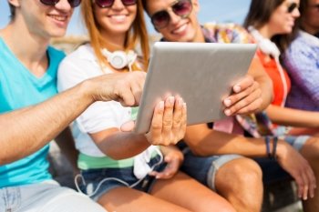 friendship, leisure, summer, technology and people concept - close up of smiling friends with tablet pc computer sitting outdoors