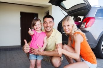transport, leisure, road trip and people concept - happy  family with little girl and hatchback car showing thumbs up at home parking space