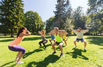 fitness, sport, friendship and healthy lifestyle concept - group of happy teenage friends exercising and doing squats at boot camp