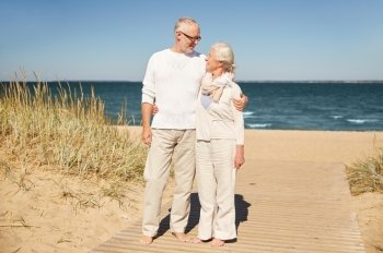 family, age, travel, tourism and people concept - happy senior couple talking on summer beach